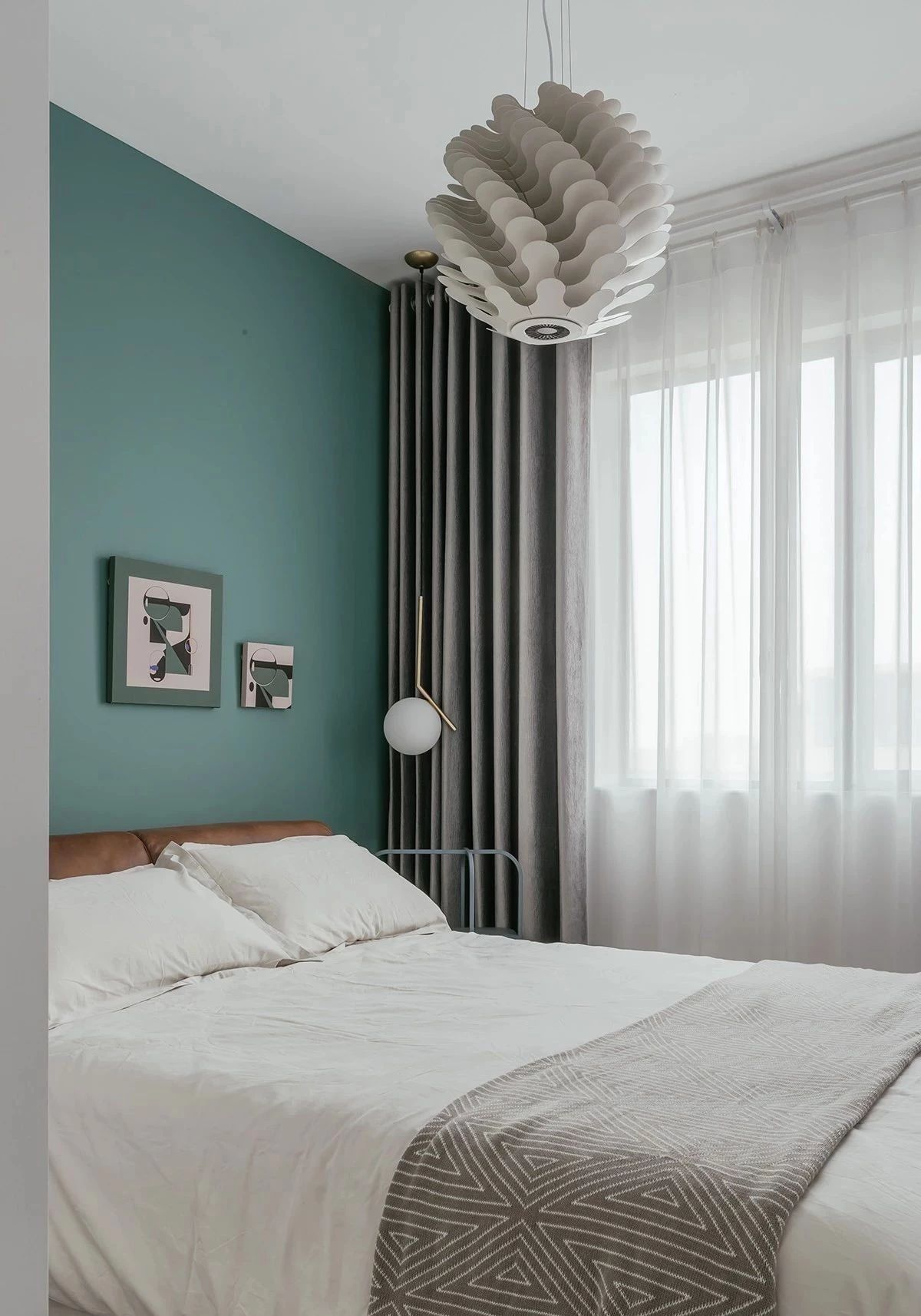 以海洋綠作為次臥床頭背景墻主色調，配上灰色窗簾，優雅靜謐